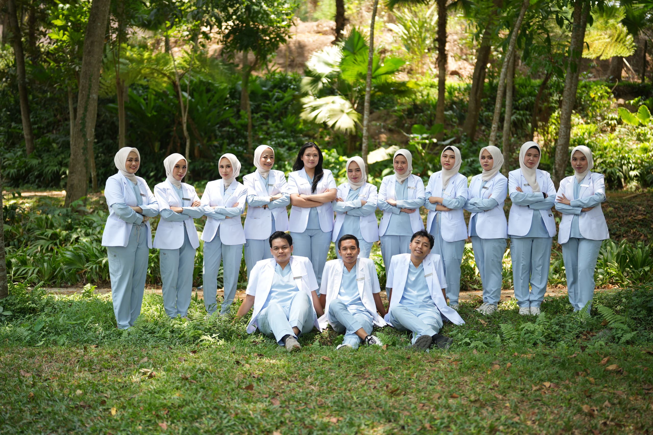Kelompok dokter berdiri dan duduk bersama di taman